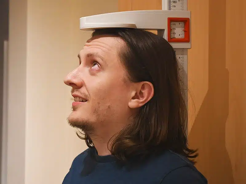 Average height for men UK: a man having his height measured against a wall chart