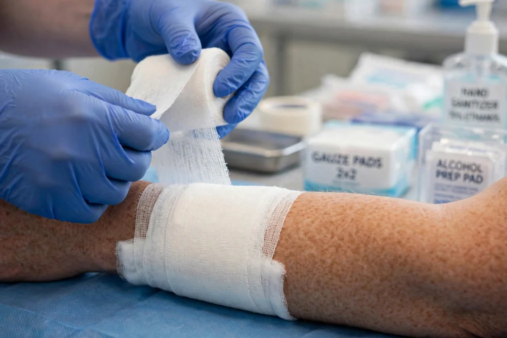 Nurse bandaging a patient's arm for a minor injury in a clinic